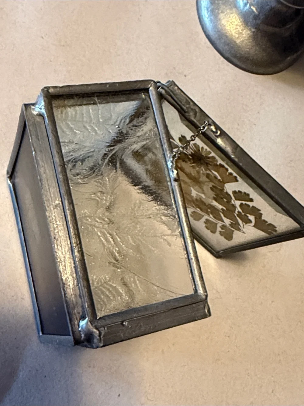 Vintage trinket box with metal edges and dried flowers on top. Mirror bottom.